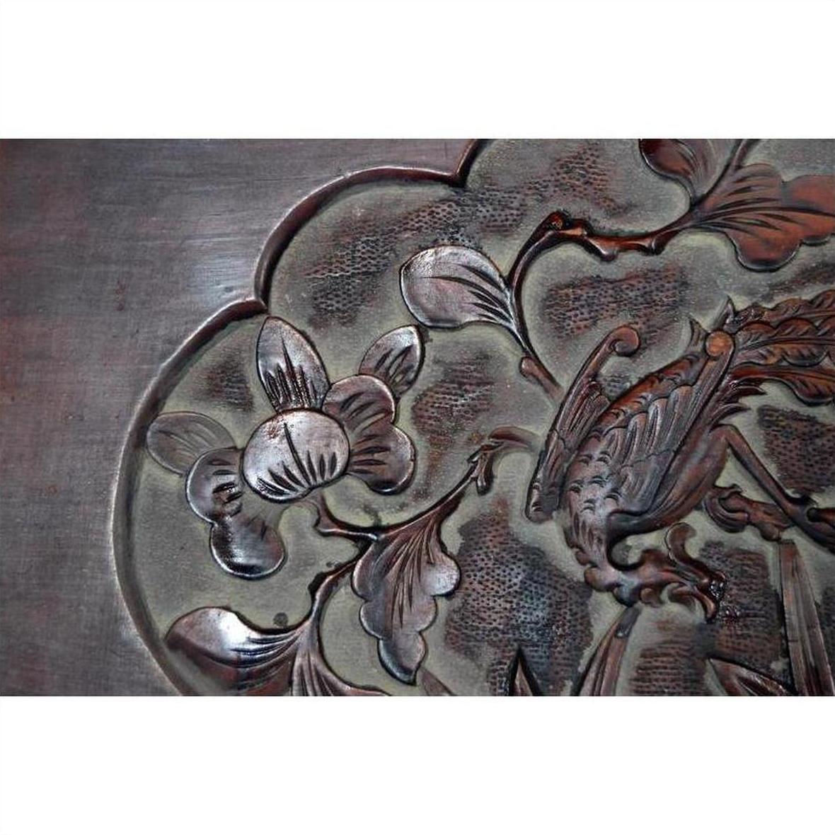 Dark rosewood lacquered Chinese wall plaque with hand-carved floral and bird design, close-up view.
