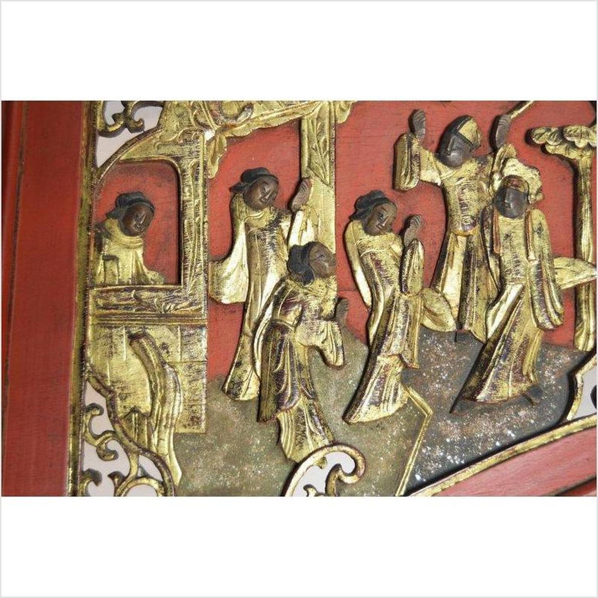 Red and gold hand-carved wooden sign with gilded figures in traditional dress, antique Chinese decor.