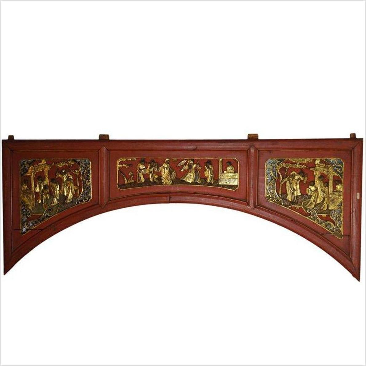 Red and gold wooden sign with hand-carved scenes of people and landscapes.