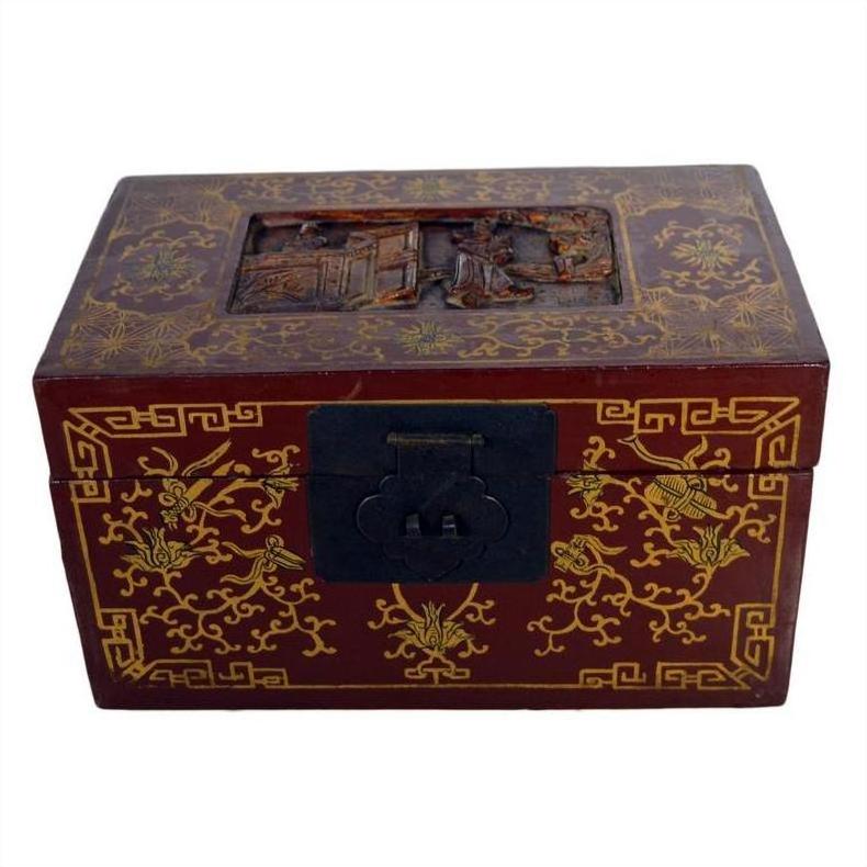 Black lacquered Chinese box with central latch and embossed stylized birdwork, ornate gilt design on lid, close-up.