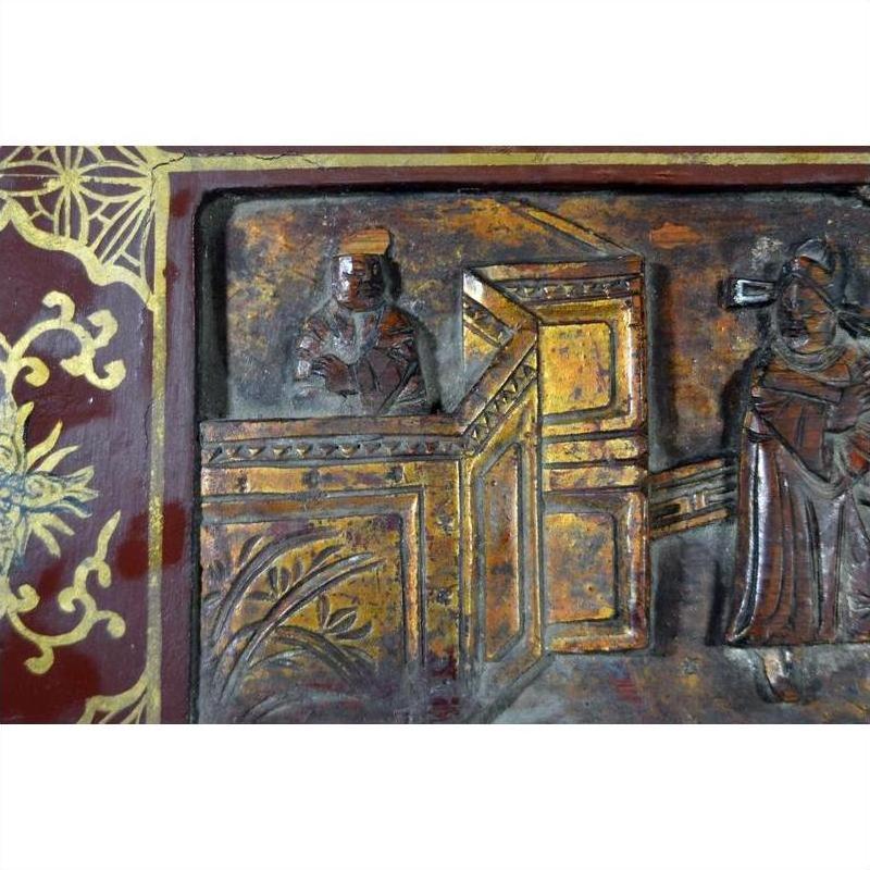 Black and gold lacquered Chinese box with central latch, ornate gilt details, and stylized birdwork on surface.