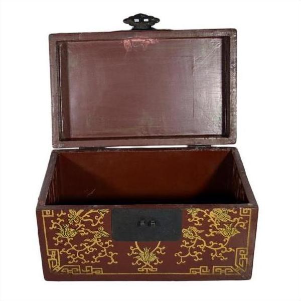 Black and gold lacquer box with gilt stylized bird designs, central latch, ornate exterior, shown on plain background.