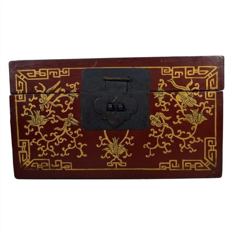 Close-up of red lacquer Chinese box with central latch and stylized bird design on surface.