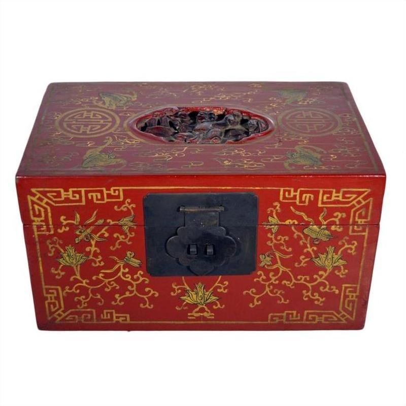 Close-up of antique Chinese lacquer box with gold phoenix and vine motifs, black clasp, and carved oval on lid.