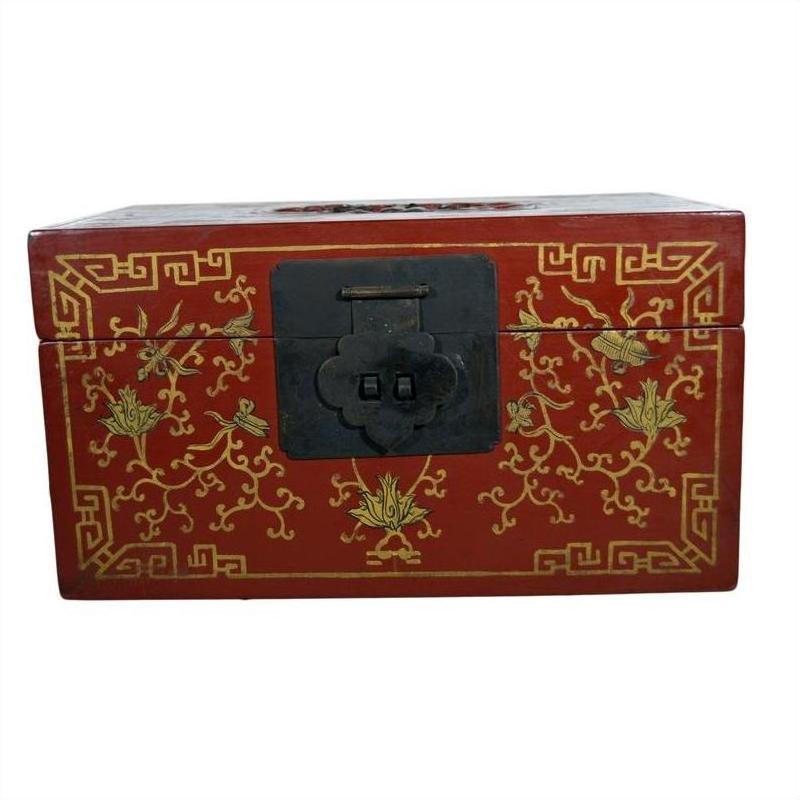 Red lacquer wood box with gilt phoenix and vine design, black metal front latch, close-up.