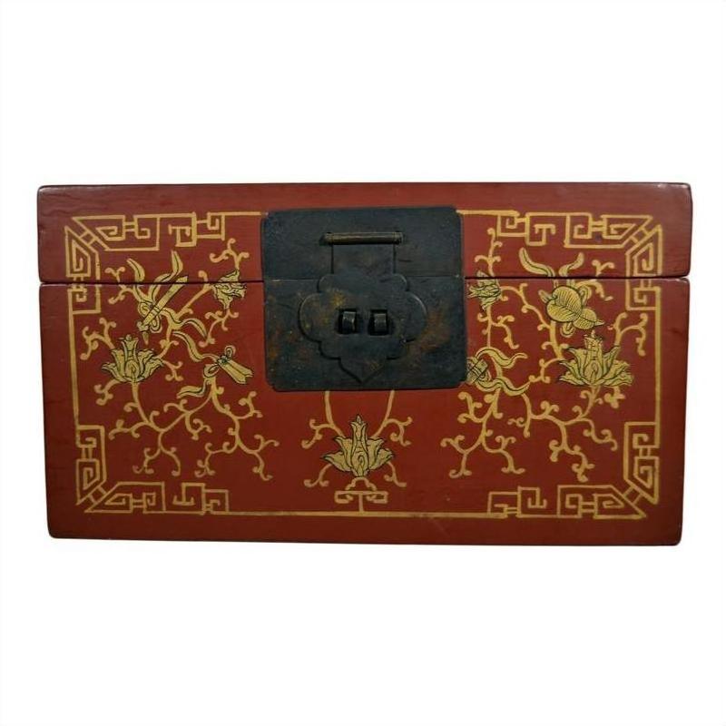 Close-up of red lacquer Chinese box with ornate gold floral inlay and black metal center latch.
