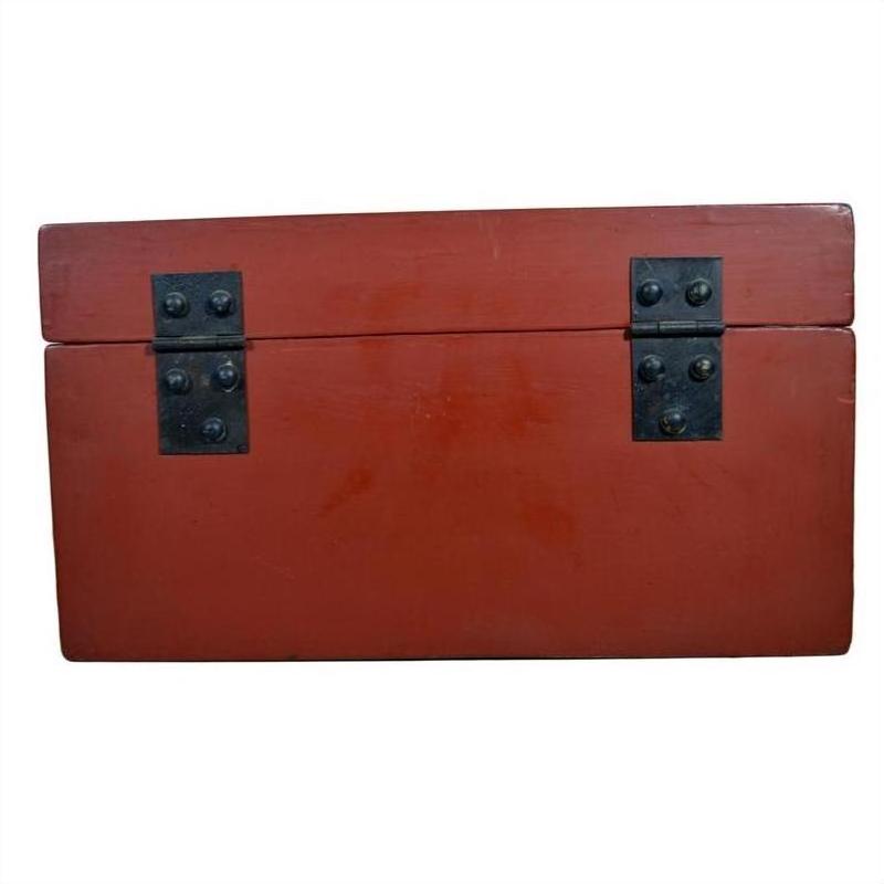 Red lacquer box with gold floral inlay, hinged lid, and two black metal hinges on front, shown against plain background.