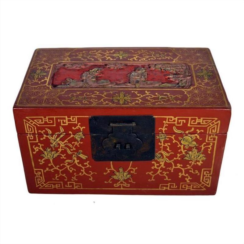 Red lacquer Chinese box with gold floral inlay, black clasp, and hand-carved lid scene, close-up view.