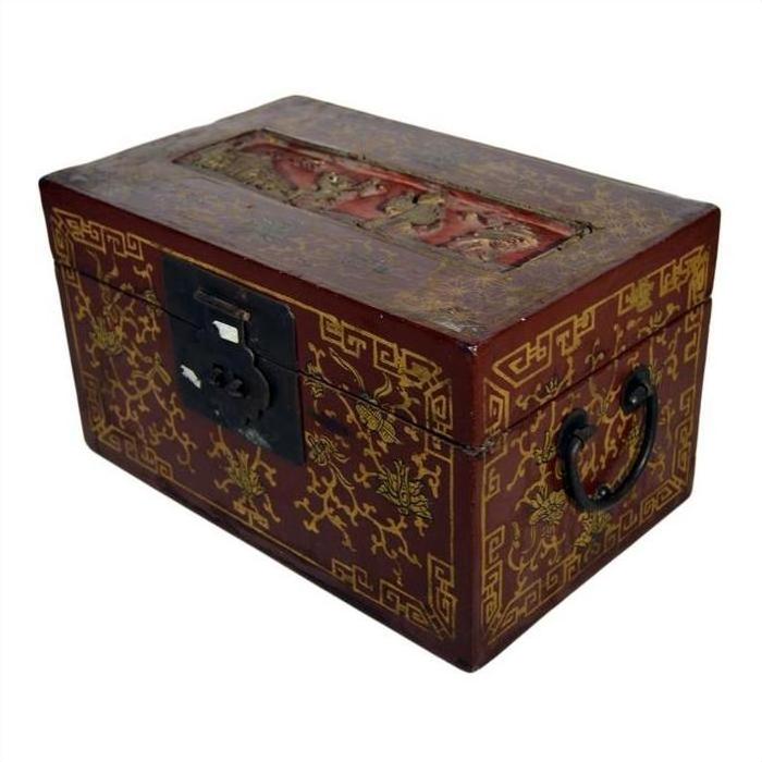 Close-up of red and gold Chinese lacquer box with raised top scene, metal latch, and side handle.