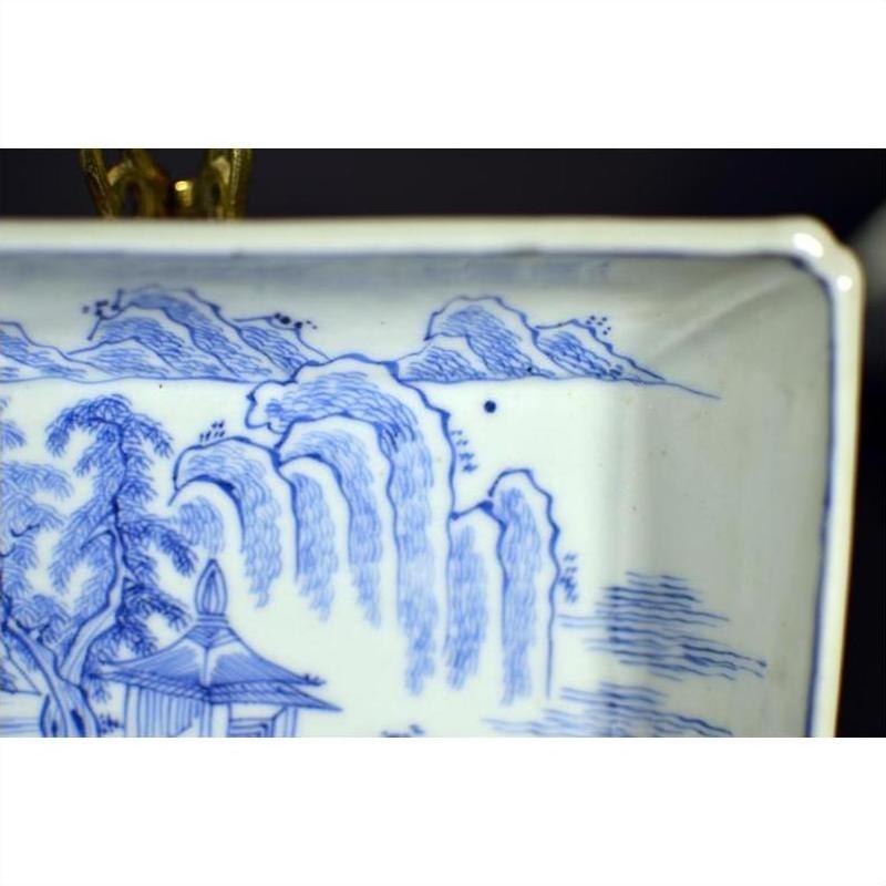 Blue and white porcelain tray close-up featuring landscape with pavilion and willow trees, antique style.