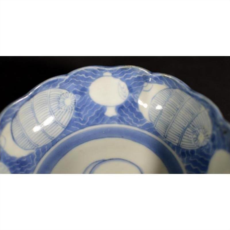 White ceramic scalloped dish with elegant rim featuring a crouching mouse and barrel cartouche, close-up view.