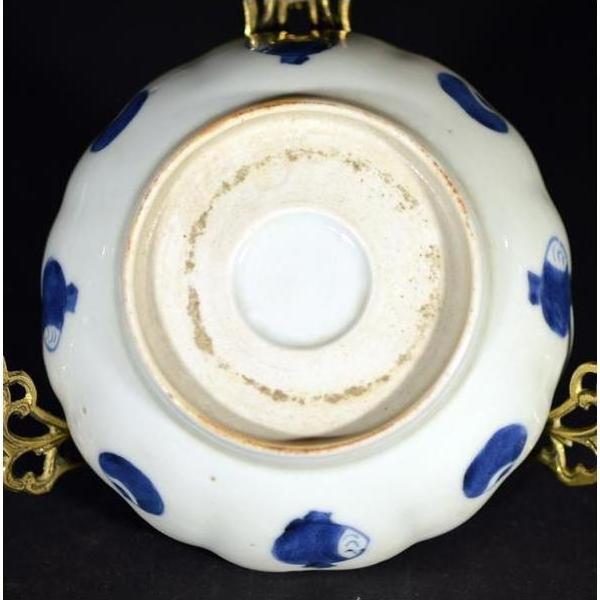 White ceramic scalloped dish with blue accents, featuring a crouching mouse and barrel cartouche, close-up view.