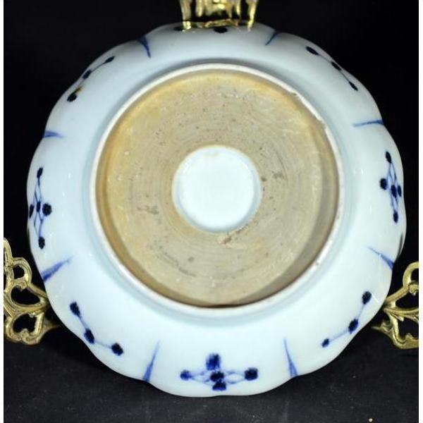 Close-up of the white porcelain Antique Fluted Plate – Wind-Swept Pine underside on an ornate gold stand.