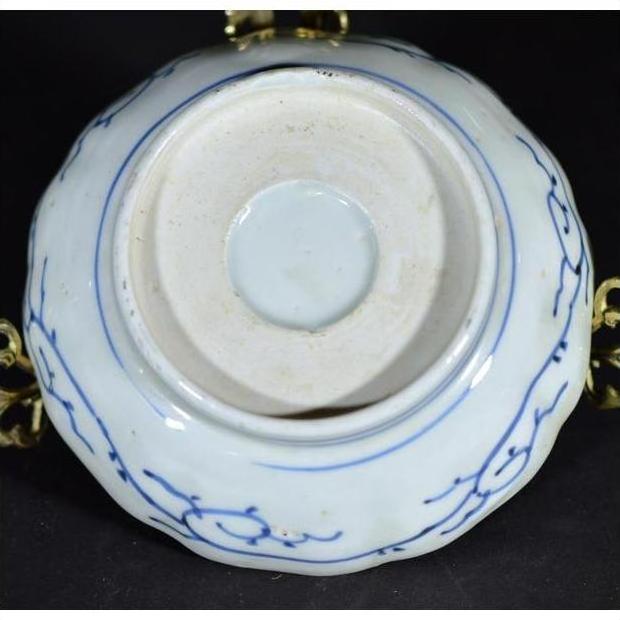 White porcelain bowl with butterfly cartouches and petal rim, shown from the bottom, antique Chinese style.