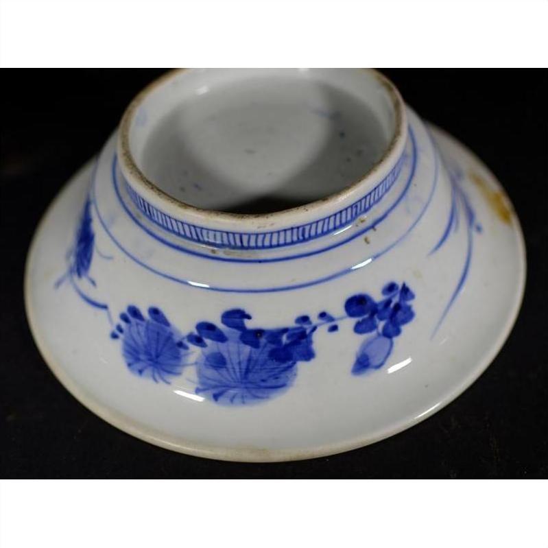 White porcelain Asian deep plate with broad blue rim and minimal center, delicate patterns, bottom view, close-up.