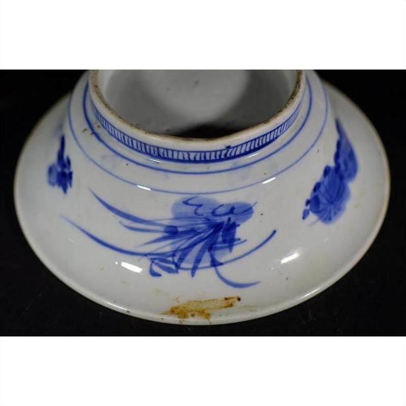 Blue and white ceramic deep plate with broad rim, minimal center, and small brown stain near bottom edge.
