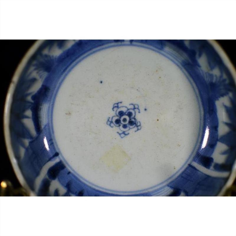 Blue and white porcelain dish with rosette medallion, blue floral pattern, and central blue emblem, close-up.