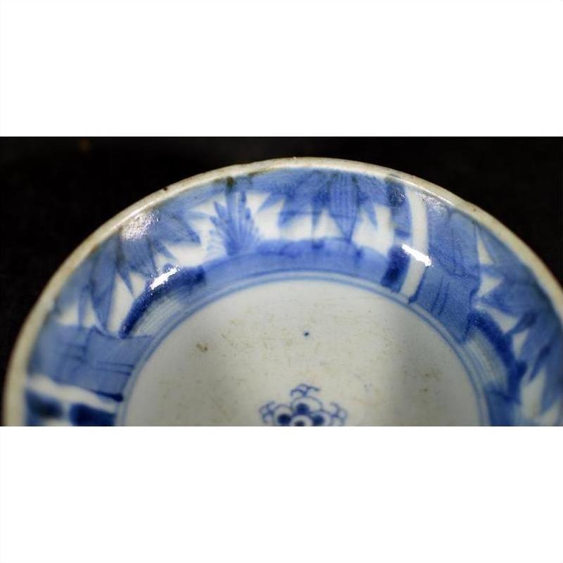 Blue and white porcelain dish with a rosette medallion and alternating patterned panels, close-up.
