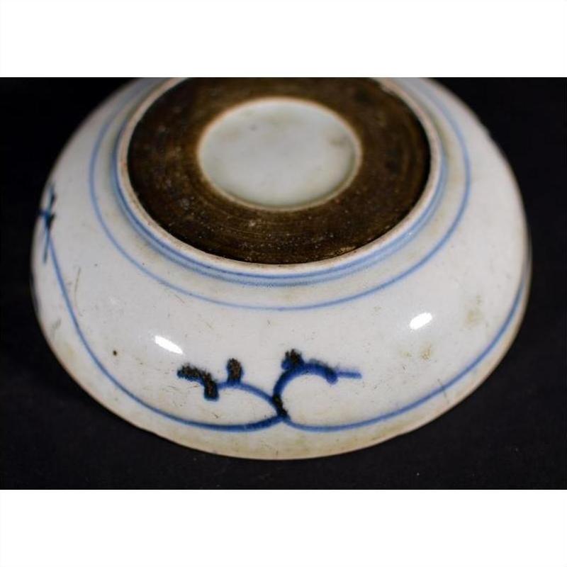 White porcelain dish with rosette medallion and alternating panels, shown upside down on a black background.