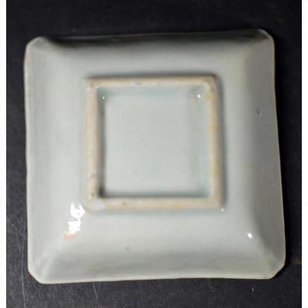 Blue and white ceramic bowl with raised petal pattern and grid texture, close-up.