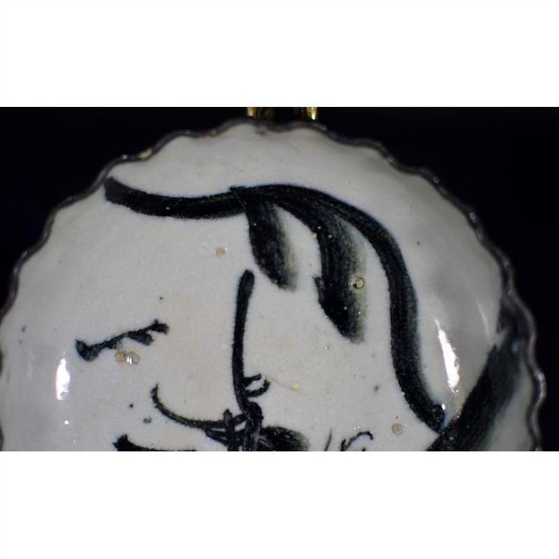 Close-up of white porcelain plate with antique ink-style bamboo branches and calligraphic brushwork.