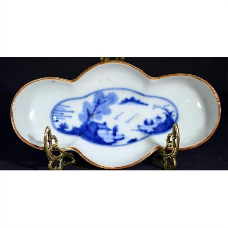 Blue and bronze antique cloud-form dish with figural river scene, displayed on a metal stand.