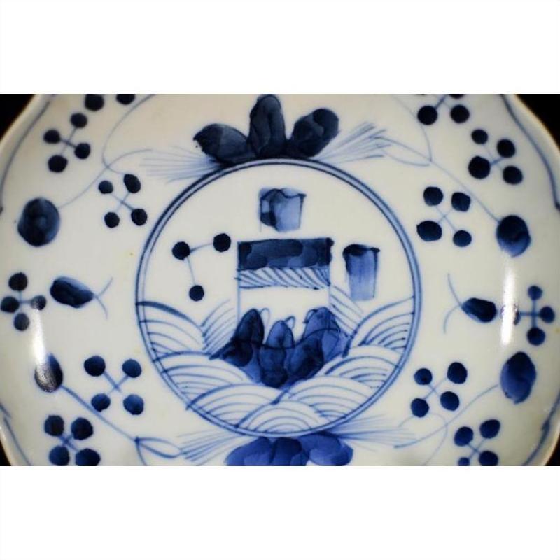 Blue and white porcelain plate with hand-painted abstract garden and floral design, close-up view.