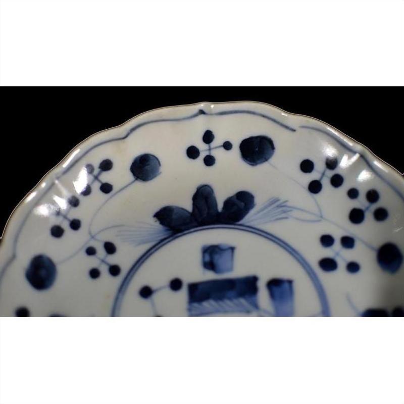 Close-up of a blue and white hand-painted Chinese porcelain plate with floral and geometric rim patterns.