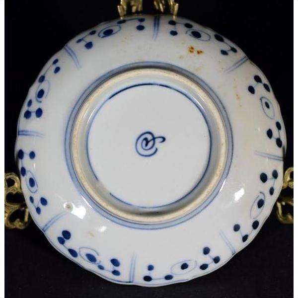 Close-up of the underside of a blue and white porcelain plate with blue circles and a central blue symbol.