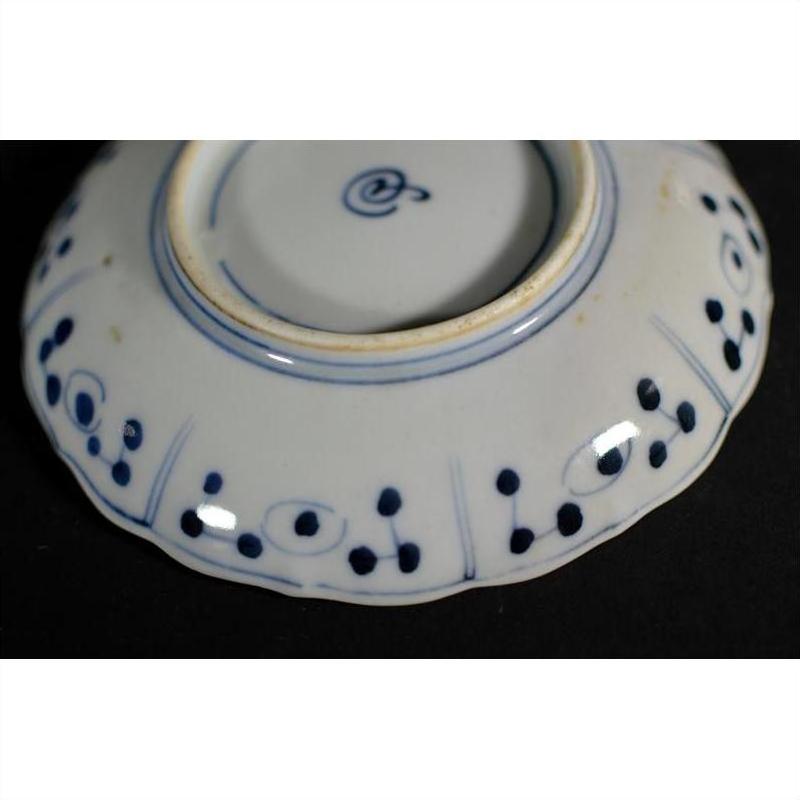 Close-up of the blue and white ceramic underside of a Chinese hand-painted porcelain plate with circles and rim dots.