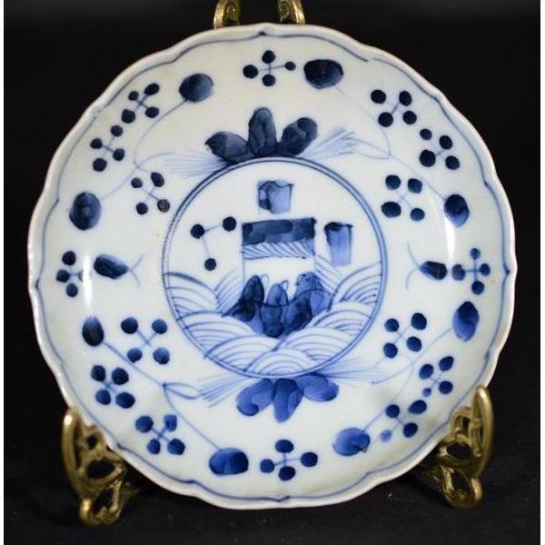 White porcelain plate with hand-painted floral and garden design, displayed on a decorative metal stand.