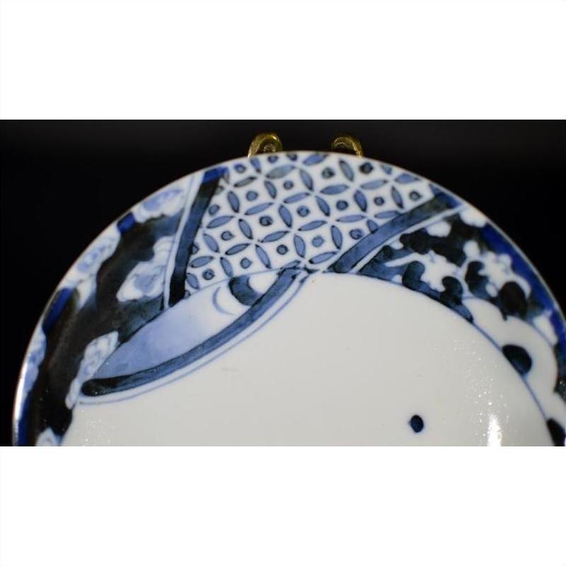 Close-up of blue and white antique Chinese porcelain plate with hand painted oxen and lattice border design.