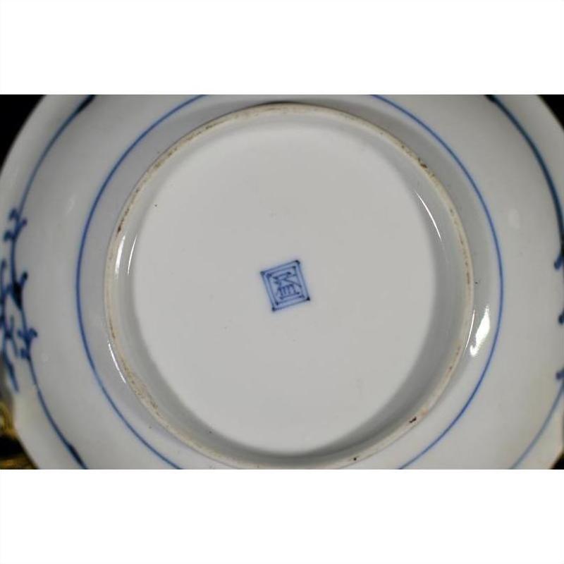 Close-up of white porcelain Chinese plate base with blue square center mark and blue rings around the foot.