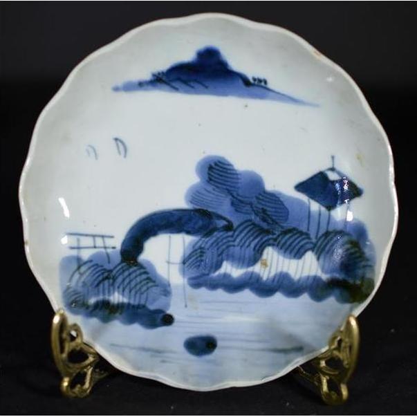 White porcelain plate with hand painted Clouded Mountain landscape design, displayed on a decorative stand.