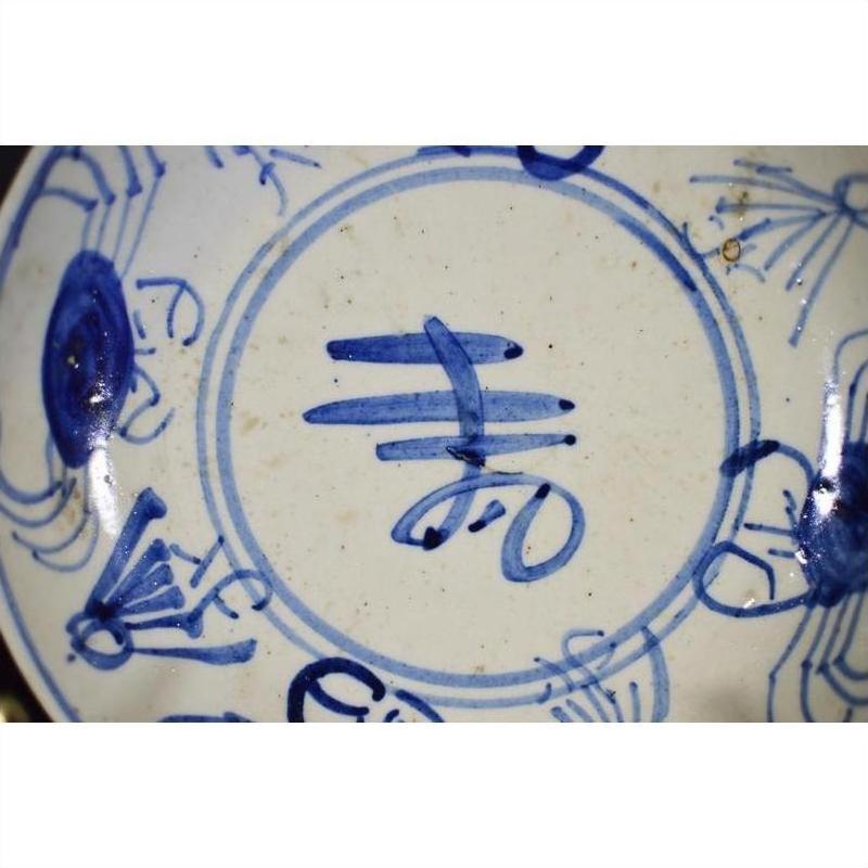 Close-up of blue Chinese characters on antique hand-painted porcelain plate, Longevity &amp; Crab design.
