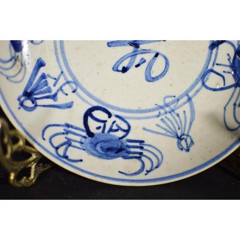 Blue and white porcelain plate with hand-painted crab and longevity motifs, antique Chinese close-up.