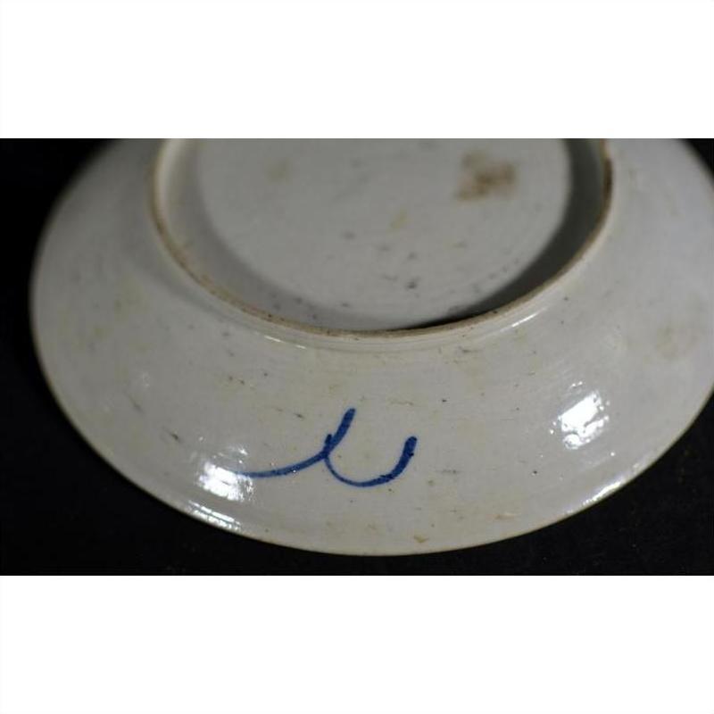 White porcelain underside close-up with blue double curved mark near the base.