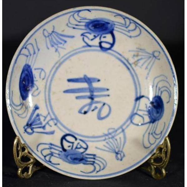 Blue and white hand-painted Chinese porcelain plate with crab design on decorative metal stand.