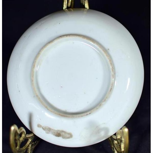 Close-up of worn underside of antique ceramic crane and turtle dish on ornate gold display stand.