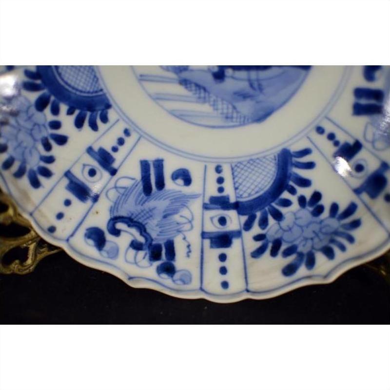 Blue and white porcelain plate with hand painted floral and geometric patterns, antique Chinese, scalloped edge, close-up.