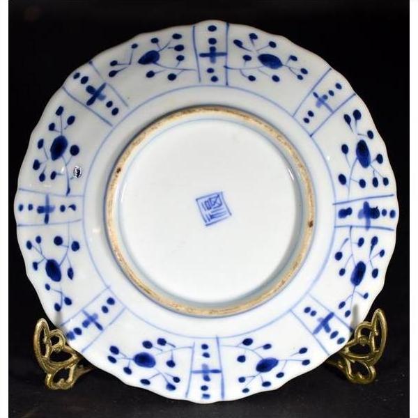 Blue and white hand painted porcelain plate with geometric dot design, blue stamp underneath, displayed on gold stand.