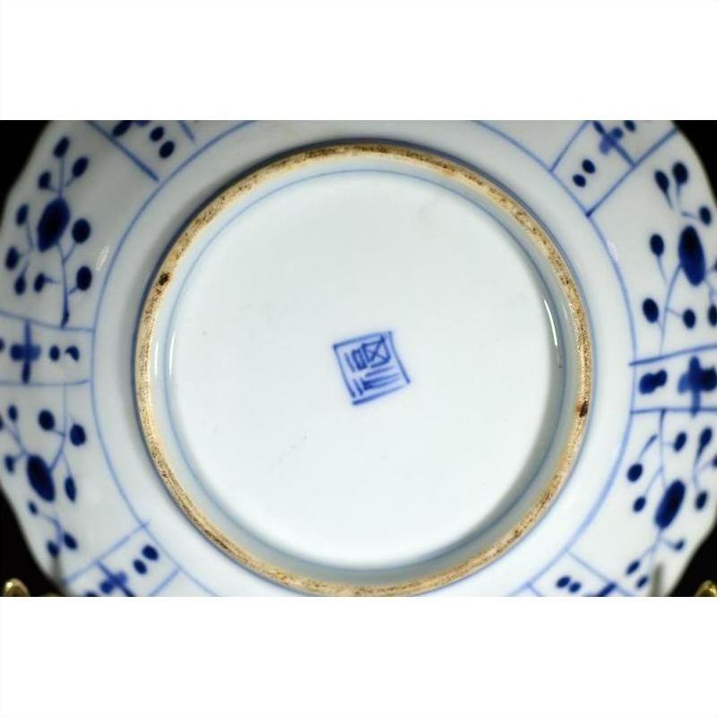 White porcelain plate base with blue painted patterns and a blue central square mark, close-up.
