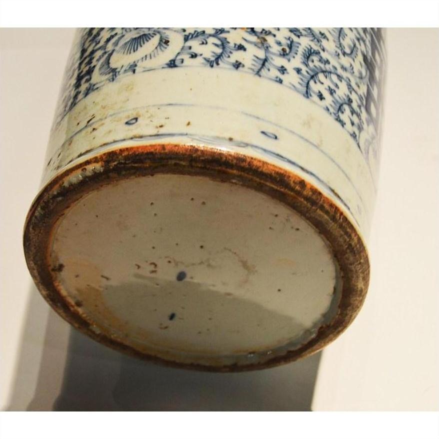Close-up of blue floral designs on the base of a hand-painted Chinese antique ceramic vase with a worn, unglazed rim.