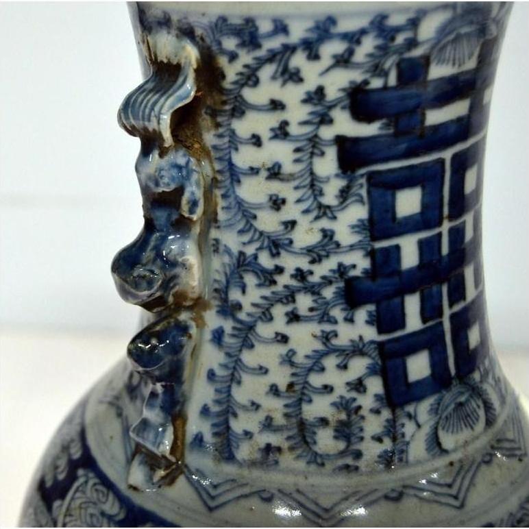 Close-up of blue and white ceramic Chinese antique vase with hand-painted patterns and sculpted neck details.