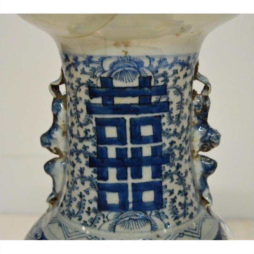 Close-up of blue and white hand-painted ceramic Chinese antique vase with central Chinese character pattern.