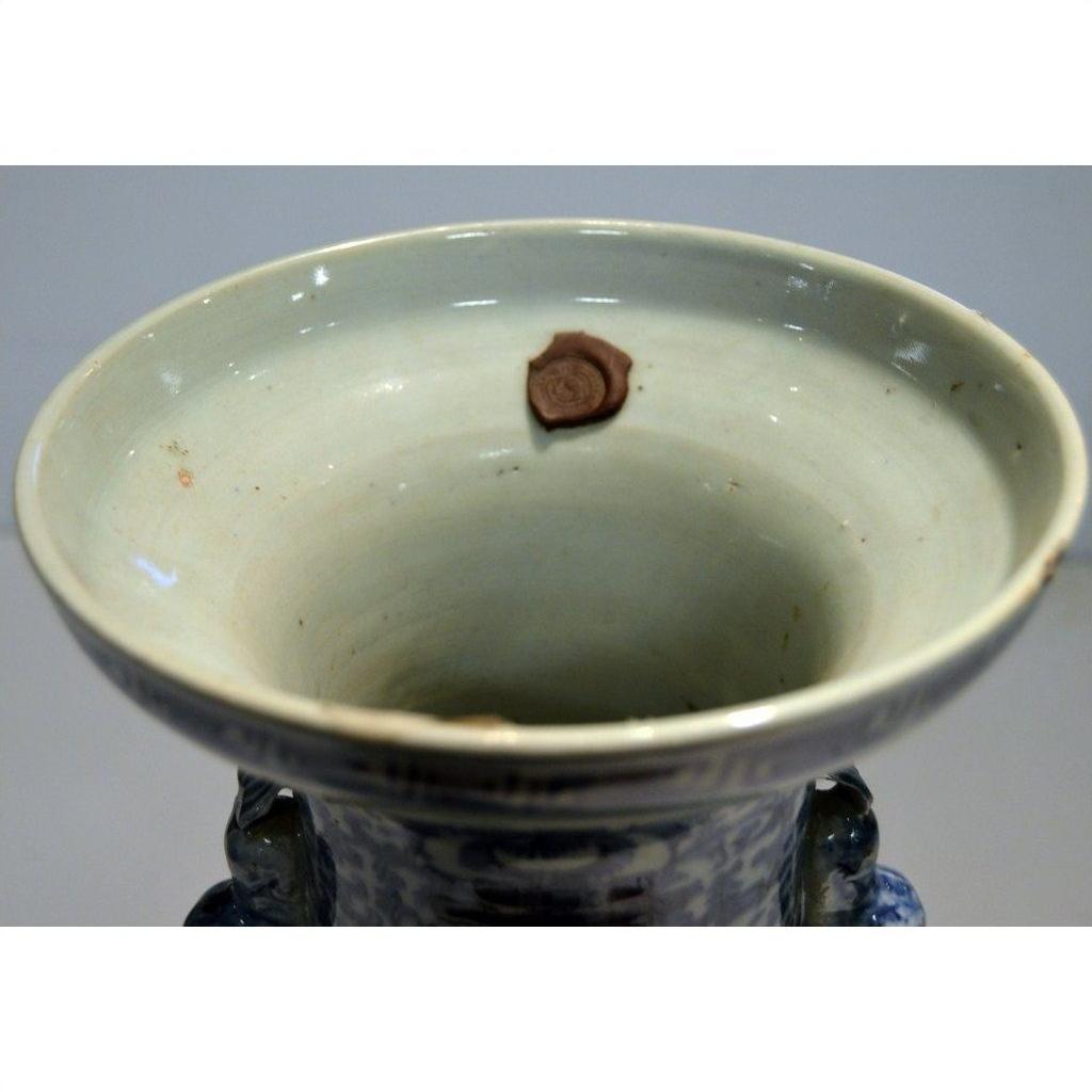 Close-up of an antique Chinese hand-painted vase with a brown wax seal and weathered inner rim.