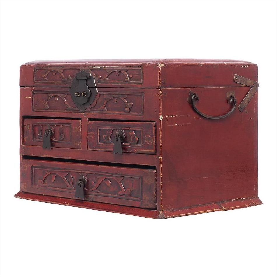Dark red lacquered Chinese jewelry box with black metal locks and multi-drawer cabinet design, close-up view.