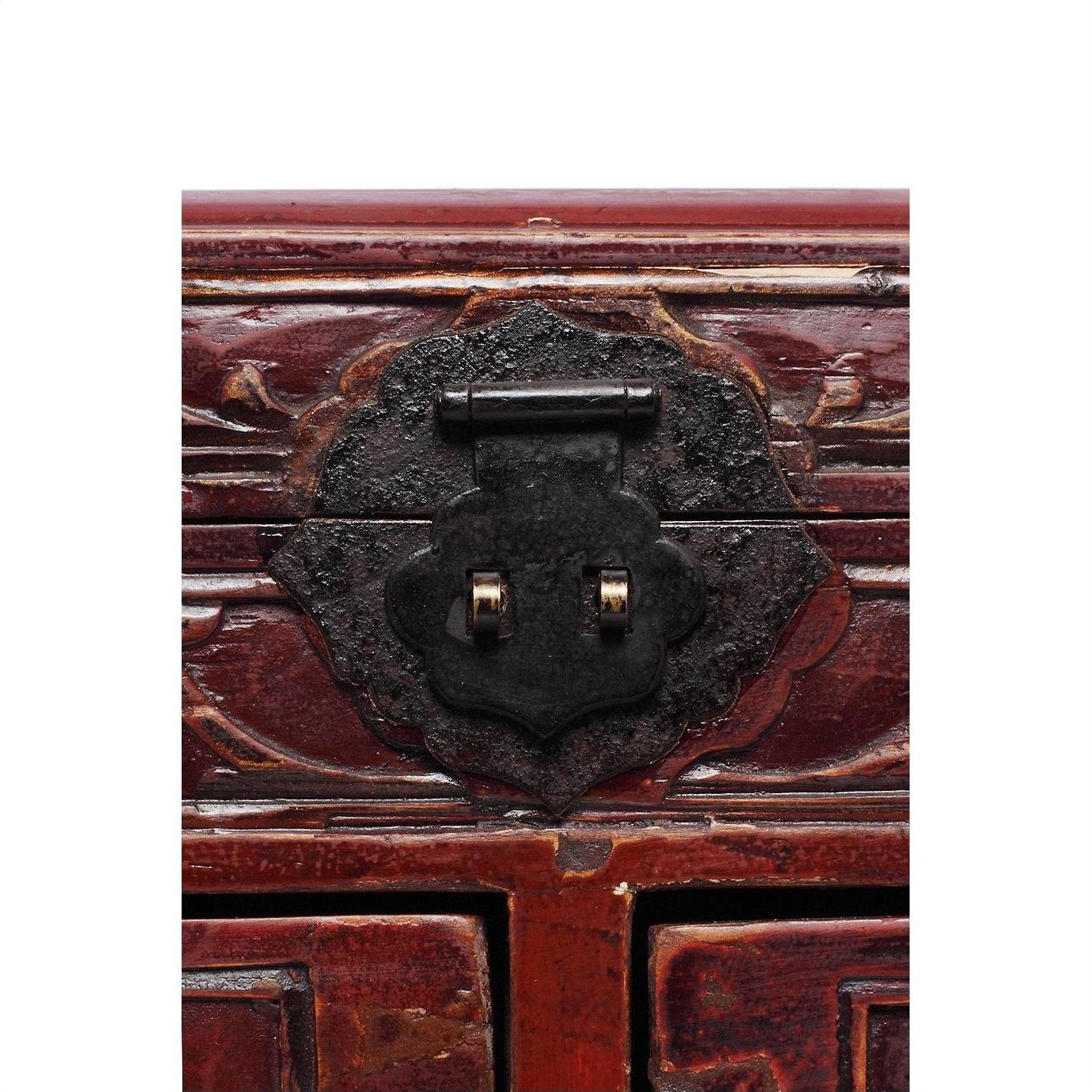 Close-up of dark metal latch on carved dark red lacquer wood Chinese jewelry box.
