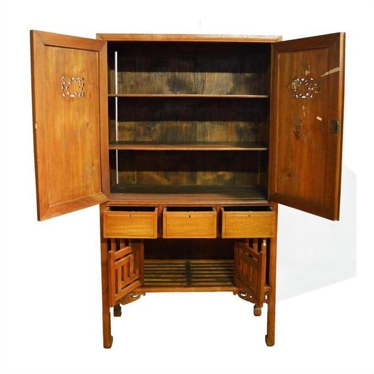 Brown wood kitchen cabinet with open top and bottom doors, shelves, three drawers, and slatted bottom shelf indoors.
