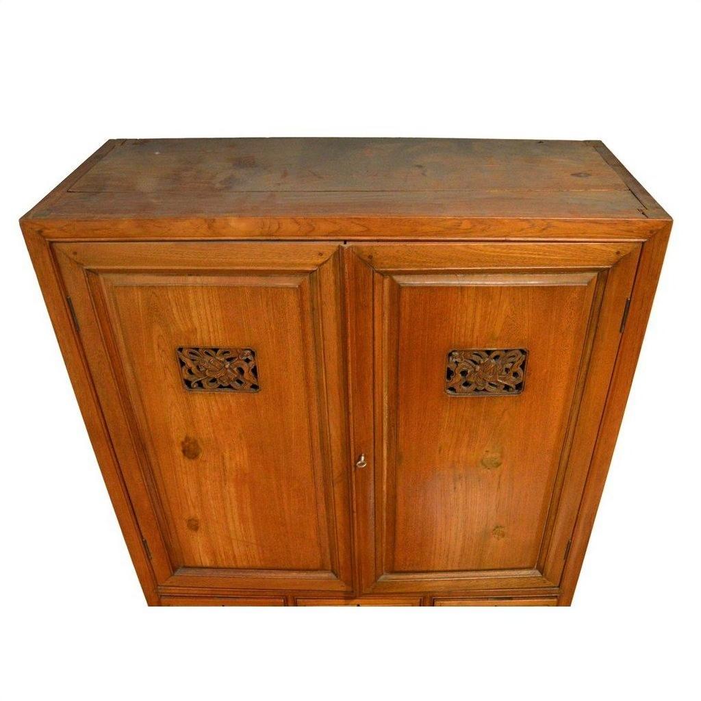 Brown wood Chinese kitchen cabinet with hand-carved framework and two paneled doors, indoor setting.